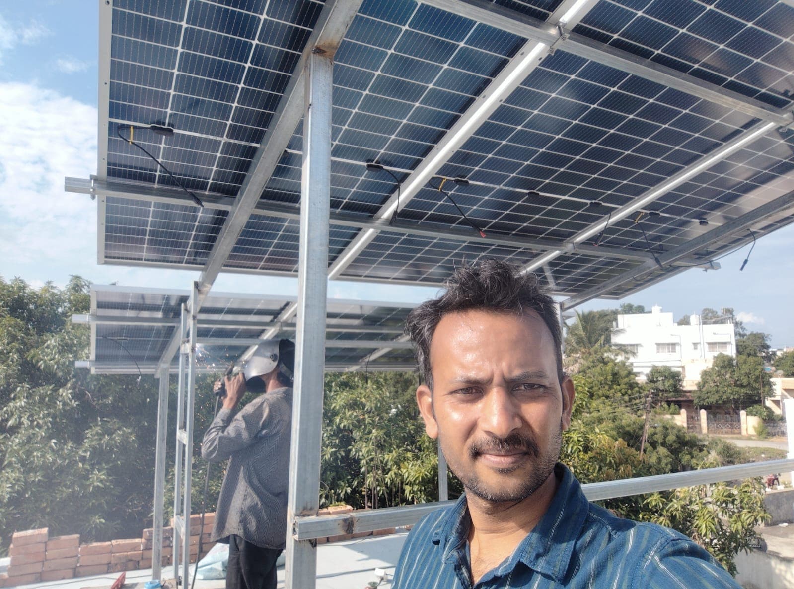 Site engineer in front of a partly built elevated solar structure